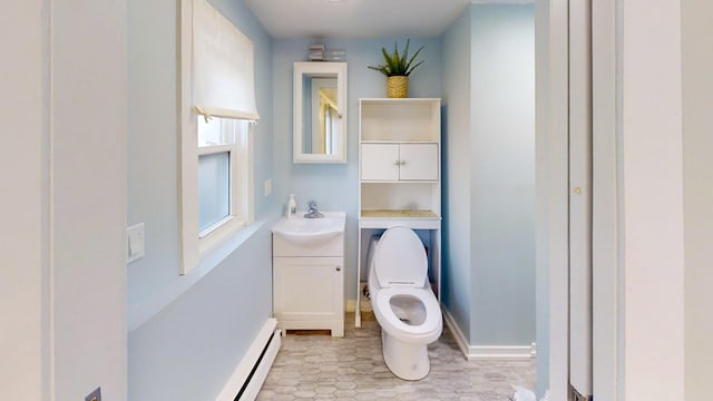 bathroom with vanity, toilet, and a baseboard heating unit