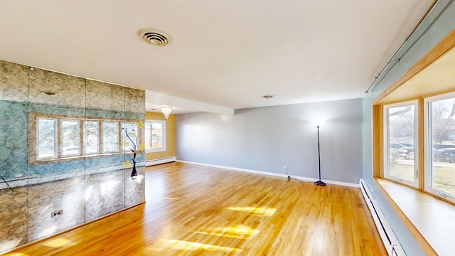 unfurnished living room featuring wood-type flooring and a baseboard radiator