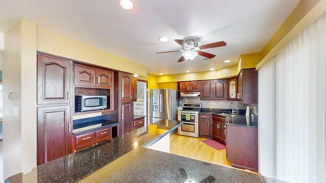 kitchen featuring ceiling fan, sink, tasteful backsplash, appliances with stainless steel finishes, and light wood-type flooring