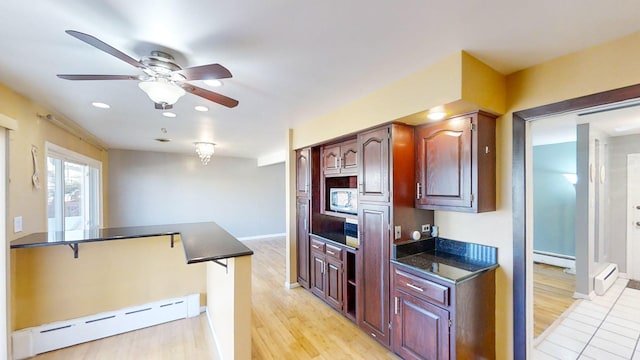 kitchen featuring kitchen peninsula, light wood-type flooring, ceiling fan, and a baseboard heating unit