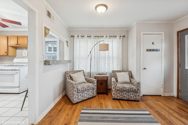 sitting room featuring ceiling fan, light hardwood / wood-style flooring, and ornamental molding