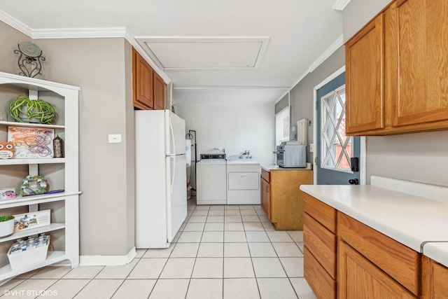 kitchen with white refrigerator, crown molding, washing machine and dryer, and light tile patterned flooring