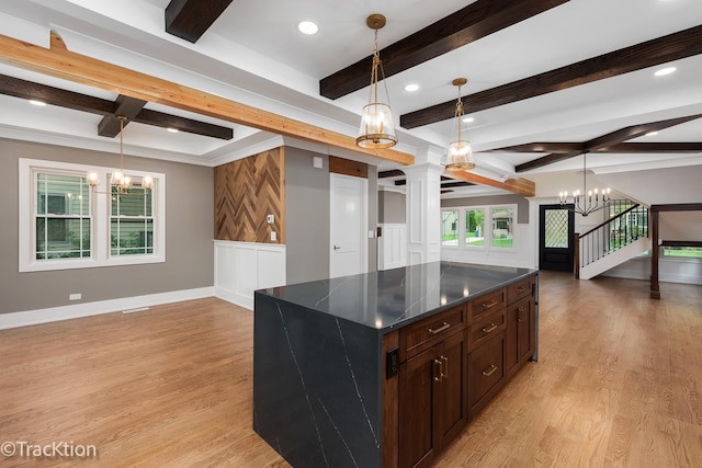 kitchen with pendant lighting, a kitchen island, light hardwood / wood-style floors, dark brown cabinets, and beam ceiling