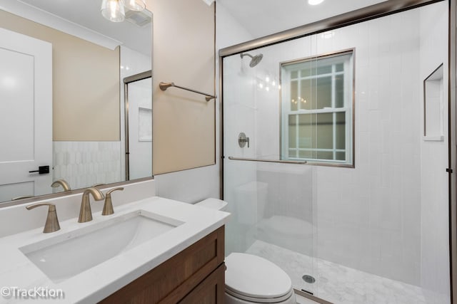 bathroom featuring vanity, toilet, and a shower with door