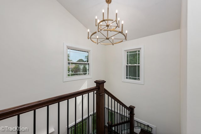 stairway featuring an inviting chandelier and vaulted ceiling