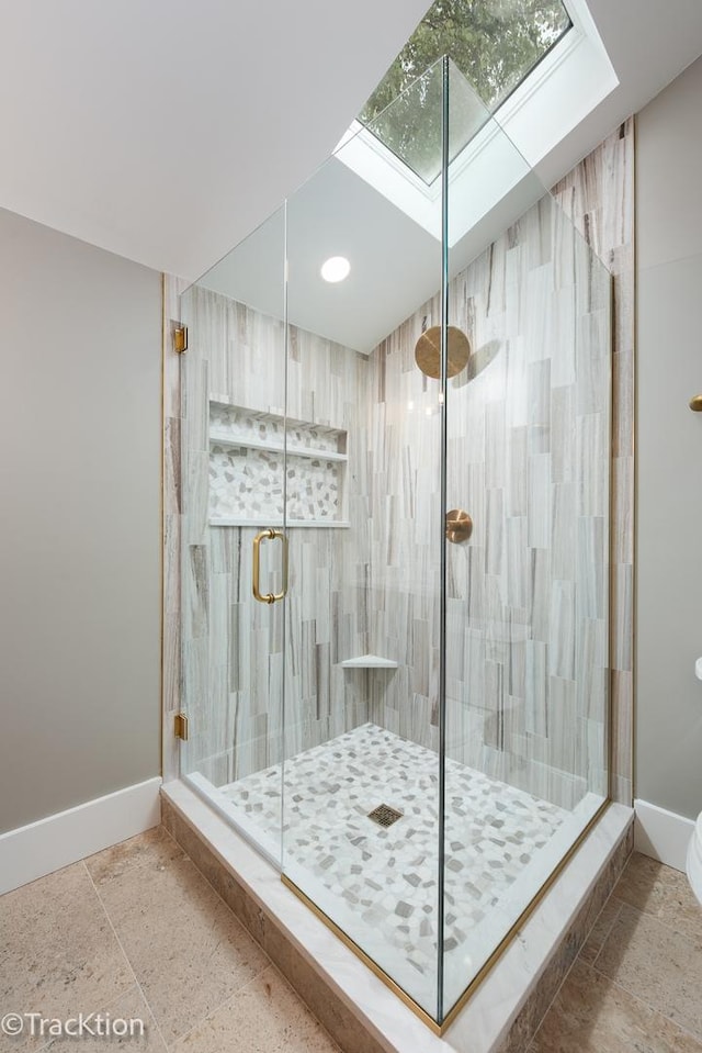 bathroom with a skylight and a shower with door