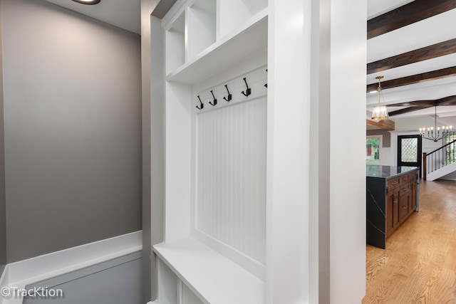 mudroom featuring a notable chandelier, beam ceiling, and light wood-type flooring