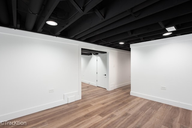 basement with light hardwood / wood-style flooring