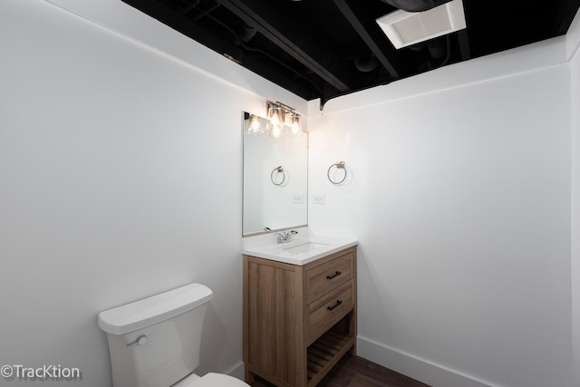 bathroom featuring wood-type flooring, vanity, and toilet