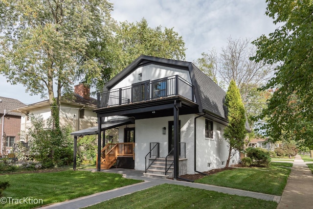 view of front of house featuring a front yard and a balcony