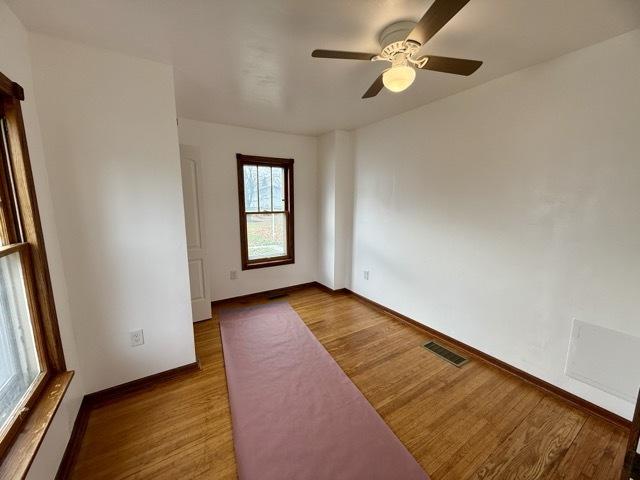 spare room with hardwood / wood-style floors and ceiling fan