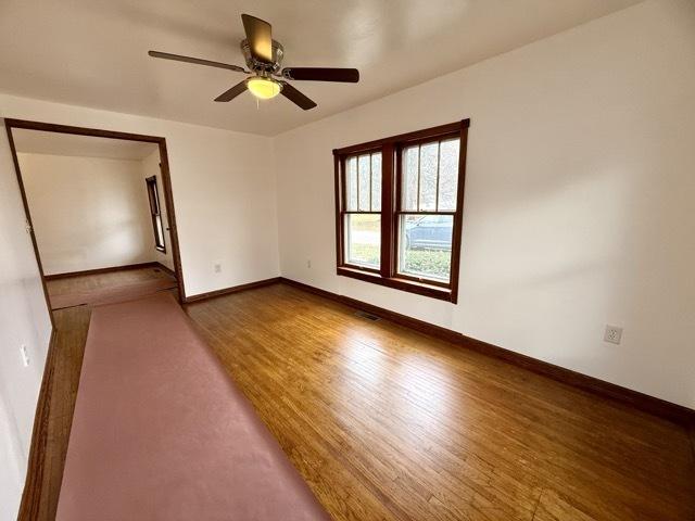 spare room with ceiling fan and wood-type flooring