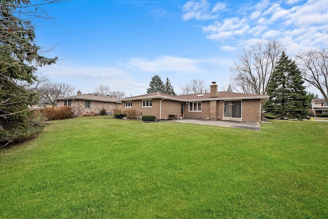 rear view of property with a yard and a patio