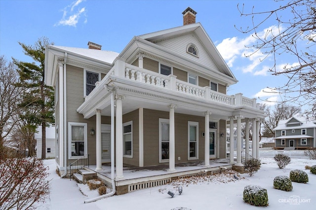 greek revival inspired property featuring a porch and a balcony