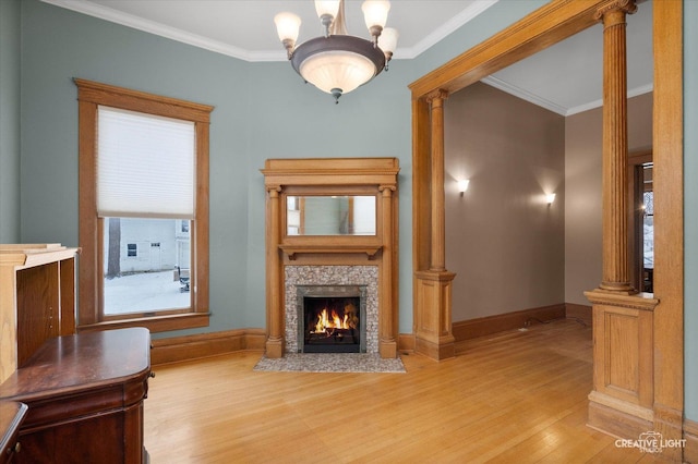 unfurnished living room featuring hardwood / wood-style flooring, ornate columns, ornamental molding, and a notable chandelier