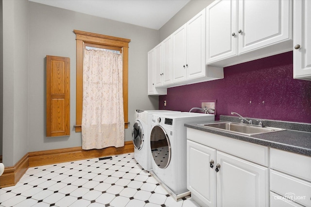 laundry area with washing machine and dryer, sink, and cabinets