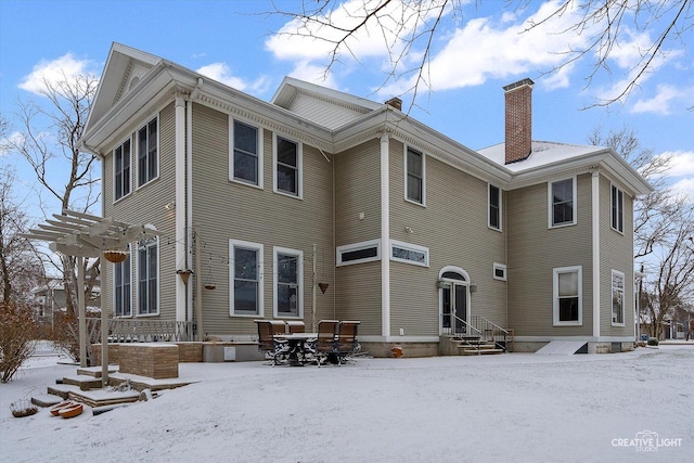 snow covered property featuring a pergola