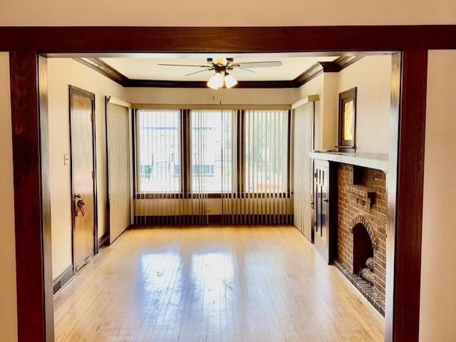7618 S Rhodes Ave, Chicago, IL 60619 - unfurnished living room with ornamental molding, ceiling fan, light wood-style flooring, a brick fireplace, and baseboards