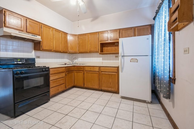 kitchen featuring white fridge, sink, black range with gas cooktop, and light tile patterned flooring