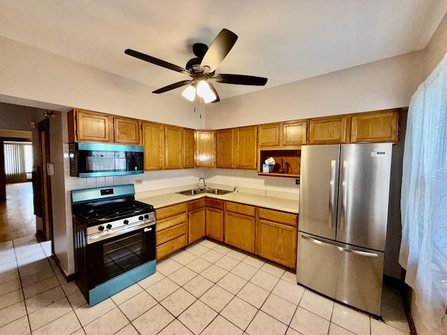 7618 S Rhodes Ave, Chicago, IL 60619 - kitchen with stainless steel appliances, brown cabinetry, a sink, decorative backsplash, and light tile patterned floors