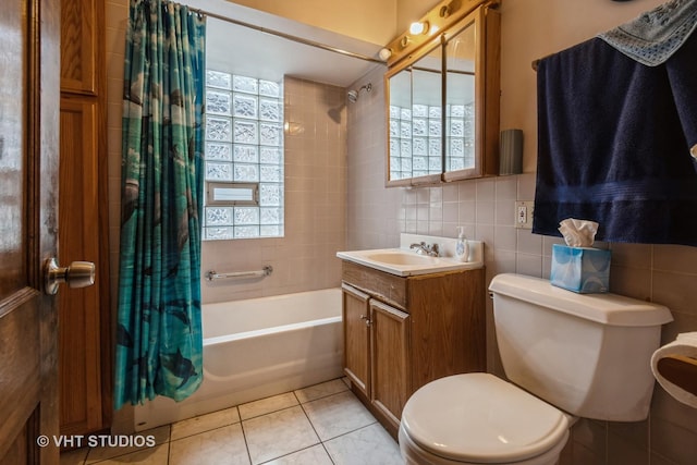 full bathroom with shower / bath combo, vanity, tile patterned floors, toilet, and tile walls