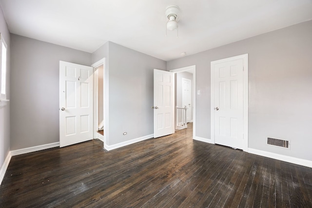 unfurnished bedroom featuring a closet and dark hardwood / wood-style floors