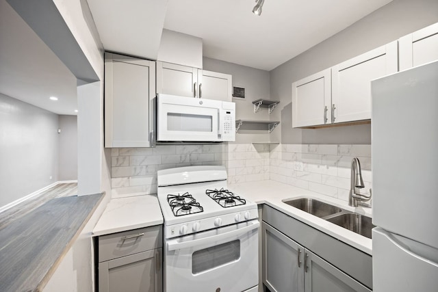 kitchen with white appliances, tasteful backsplash, gray cabinetry, and sink