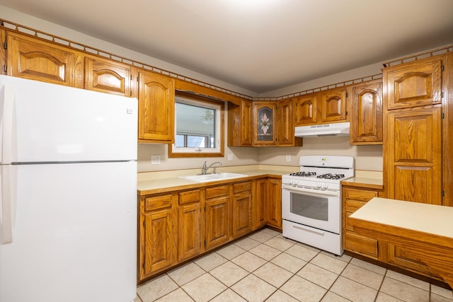 kitchen featuring light tile patterned floors, white appliances, and sink