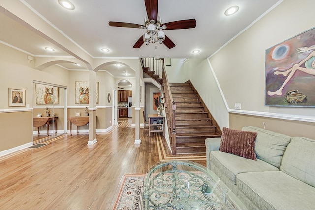 living room featuring ceiling fan, crown molding, and wood-type flooring