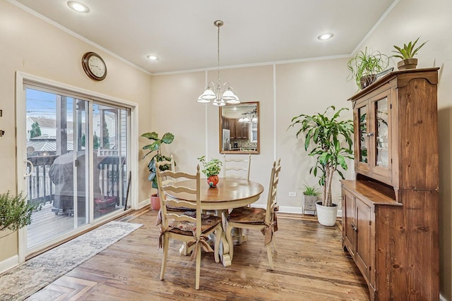 dining room featuring a chandelier, light hardwood / wood-style flooring, and ornamental molding