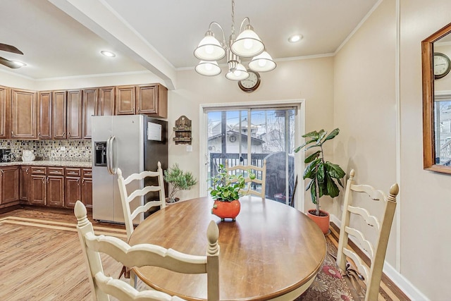 dining space featuring ornamental molding, a chandelier, and light wood-type flooring