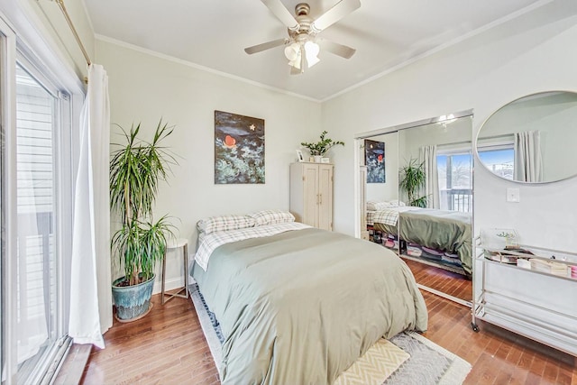 bedroom featuring hardwood / wood-style flooring, ceiling fan, ornamental molding, and a closet