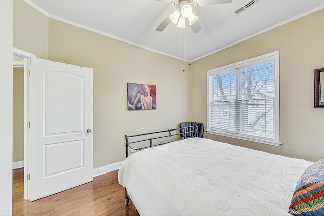 bedroom featuring hardwood / wood-style floors, ceiling fan, and ornamental molding