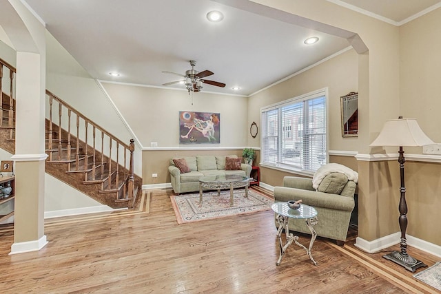 living room with hardwood / wood-style floors, ceiling fan, and ornamental molding