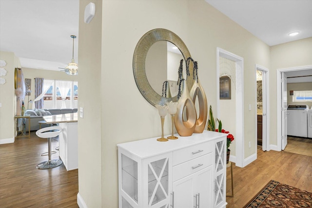 hallway with dark hardwood / wood-style flooring and washer and clothes dryer