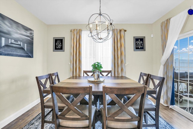 dining space featuring hardwood / wood-style floors and an inviting chandelier