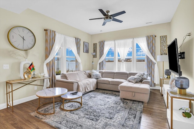 living room featuring ceiling fan and dark hardwood / wood-style floors