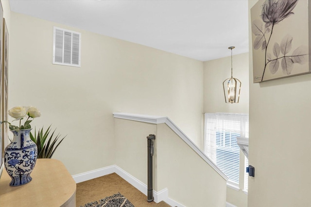 stairway featuring a chandelier