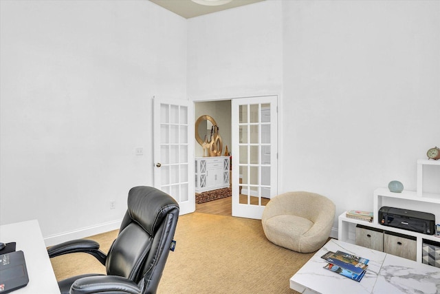 carpeted home office with french doors