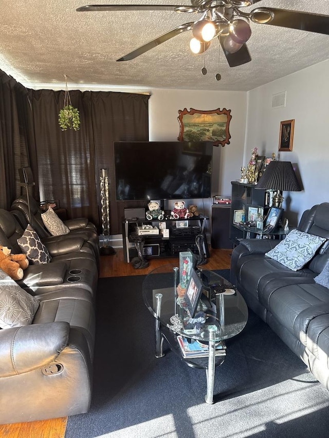 living room with ceiling fan and a textured ceiling