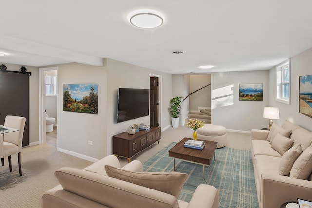 living room featuring a barn door and light carpet