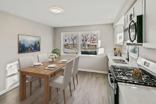 dining space featuring light hardwood / wood-style floors and sink