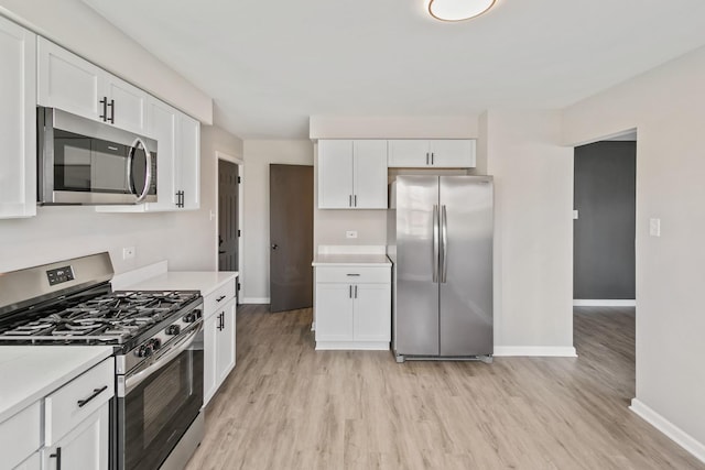 kitchen featuring white cabinets, light wood-type flooring, and appliances with stainless steel finishes