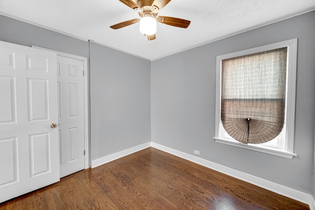 interior space featuring ceiling fan, a closet, dark wood-type flooring, and multiple windows