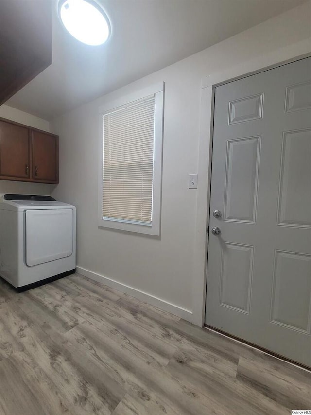 laundry room featuring washer / dryer, cabinets, and light wood-type flooring