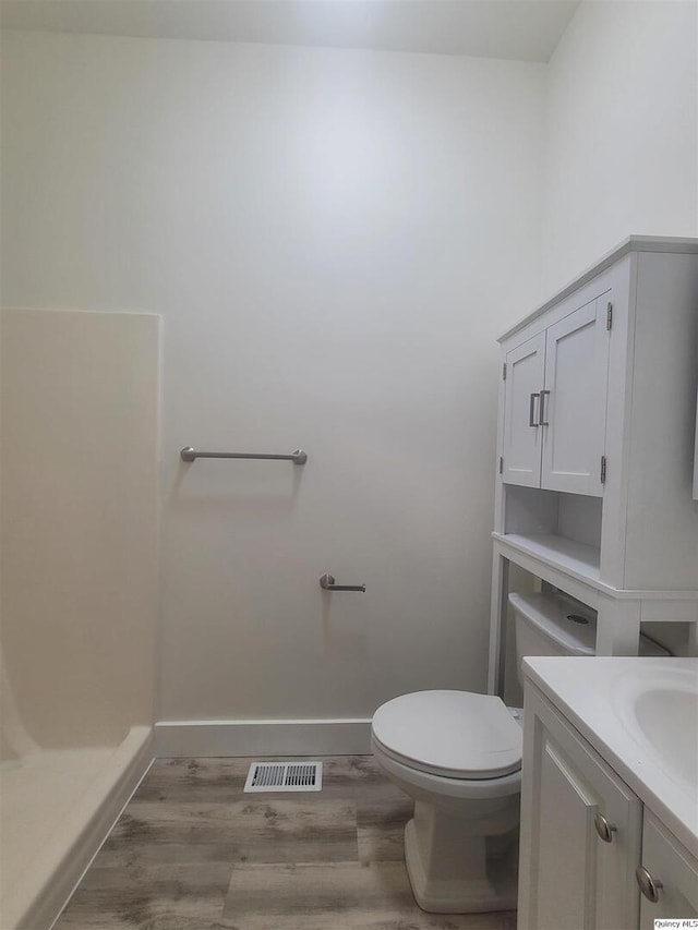 bathroom with hardwood / wood-style flooring, vanity, and toilet