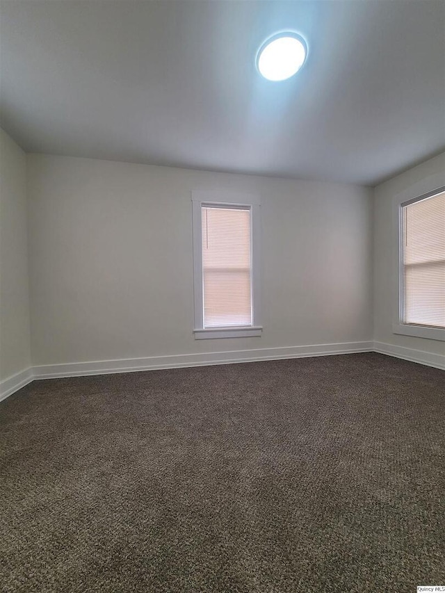 carpeted spare room featuring a healthy amount of sunlight