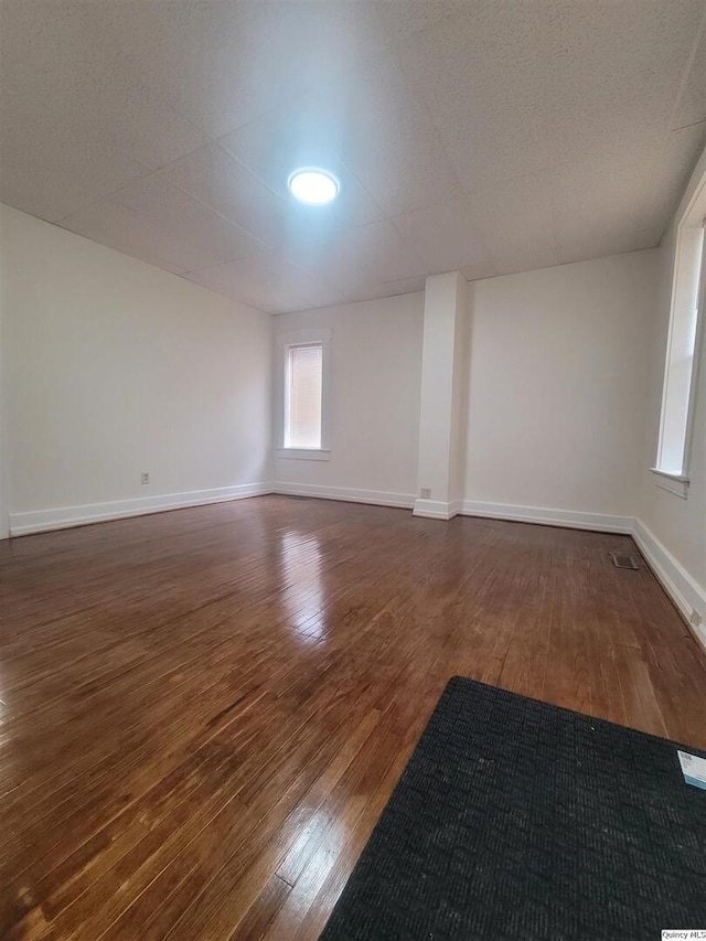 unfurnished room with dark hardwood / wood-style floors