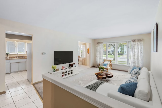 living room with plenty of natural light, light tile patterned flooring, and sink