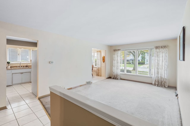 spare room featuring light colored carpet and sink